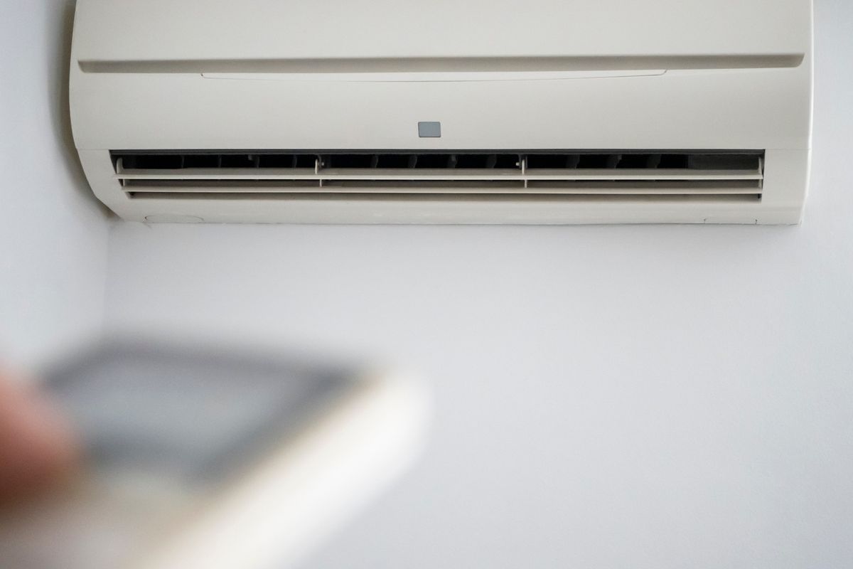Climatizzatore a parete acceso, con il telecomando sfocato in primo piano