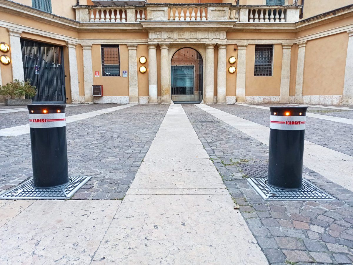 Due dissuasori automatici a scomparsa con luci di segnalazione all'ingresso del cortile di un palazzo storico
